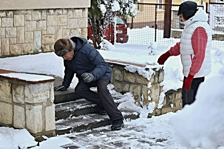 Image of an elderly man and his wife after slipping on icy steps in freezing temperatures.